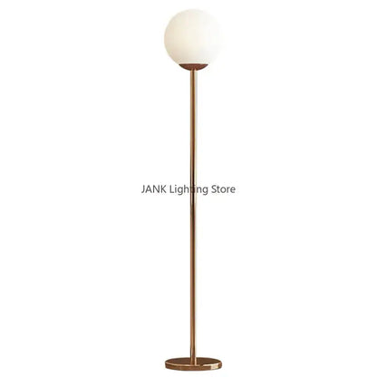 A modern brass floor lamp with a tall pole and white glass ball shade ideal for bedroom and study decorbites glass ball