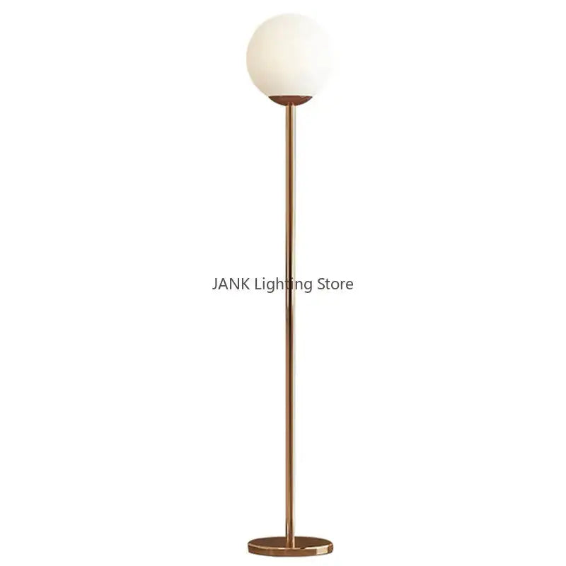 A modern brass floor lamp with a tall pole and white glass ball shade ideal for bedroom and study decorbites glass ball