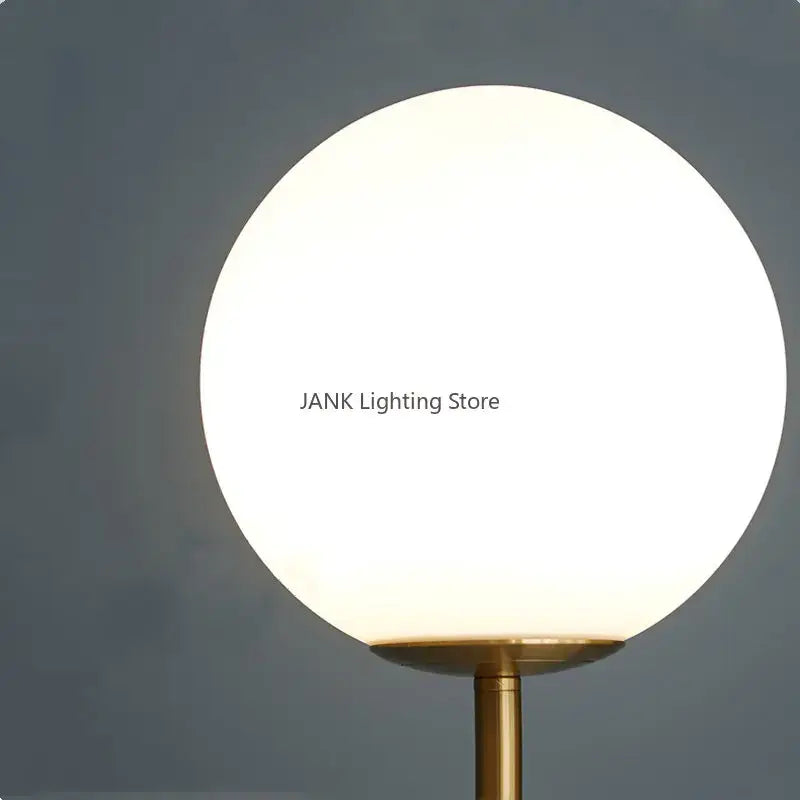 Modern brass glass ball floor lamp with frosted white spherical glass shade and brass-finished metal base for bedroom decorbites floor lamp