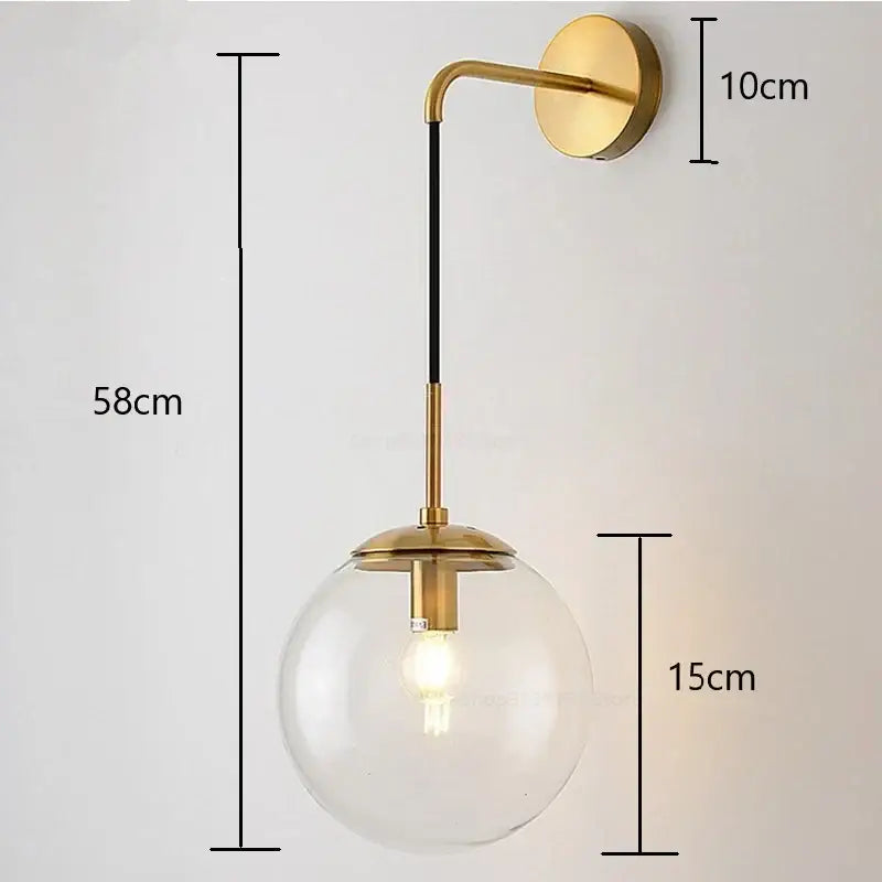 A modern brass wall light with clear glass ball led globe and black accent rod for bedroom decorbites glass ball style