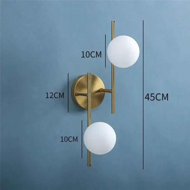 Modern brass glass ball led wall light features a gold-toned wall sconce with two frosted white glass ball shades