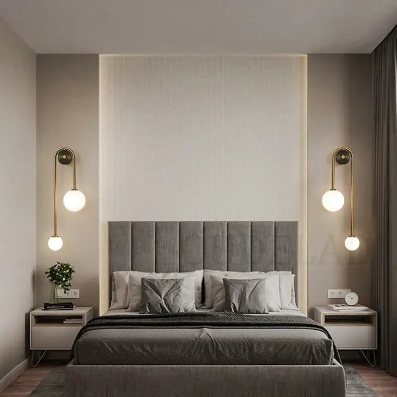 Gray tufted fabric headboard with vertical stitching paired with modern brass decorbites glass ball led wall light for bedroom