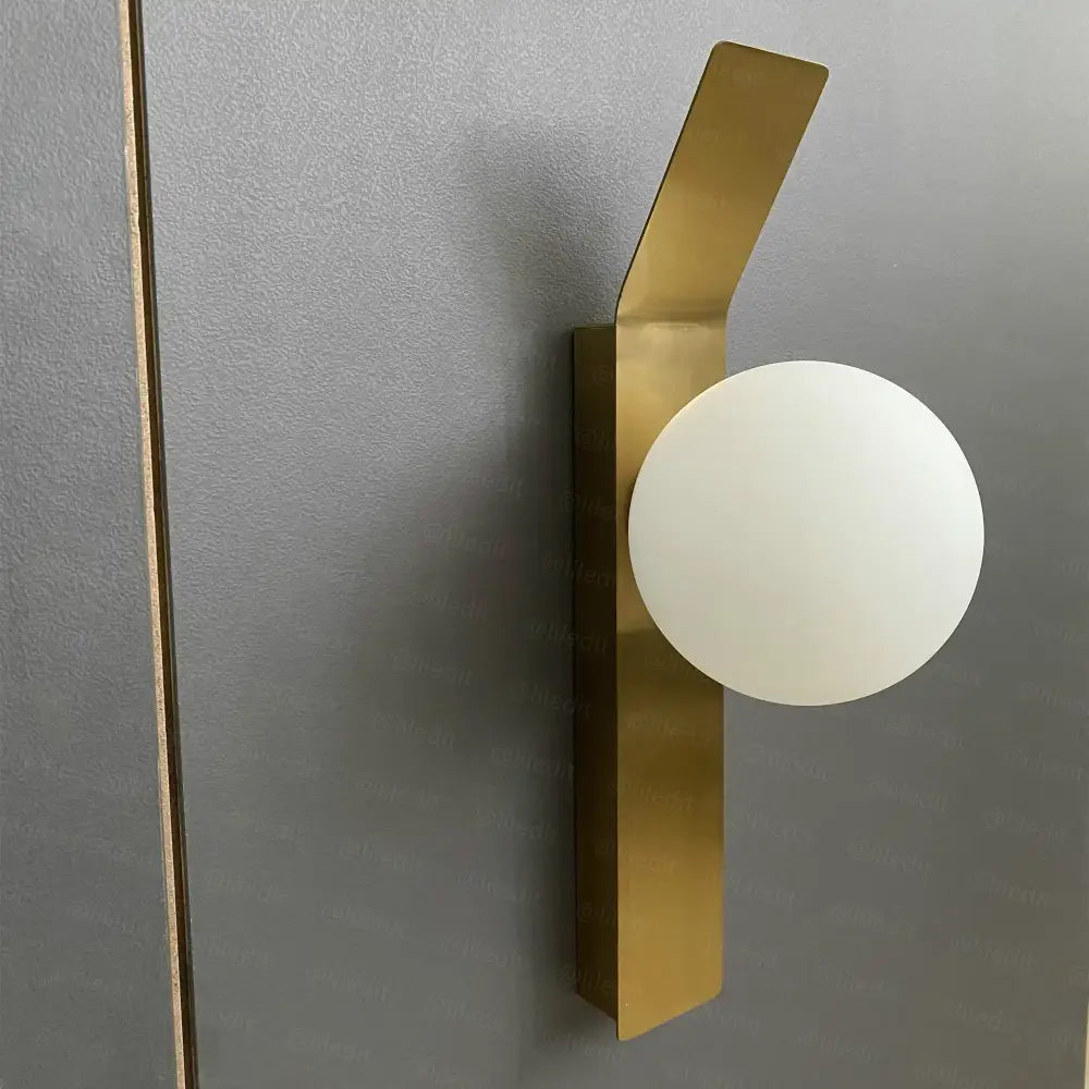 Modern brass glass ball led wall sconce with a gold-toned rectangular base and frosted white glass ball for bedroom decor