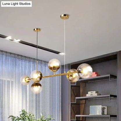 DecorBites™ 6-light linear dining room pendant with brass finish and smoke gray glass ball shades in minimalist design