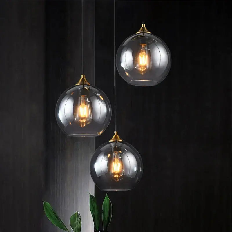 Modern brass glass ball pendant light featuring three spherical glass ball pendants with brass accents for dining decorbites