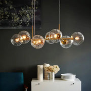 Modern brass glass ball pendant light featuring clear glass globe and warm glowing bulbs ideal for kitchen decorbites decor
