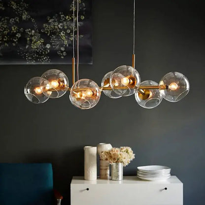 Modern brass glass ball pendant light featuring clear glass globe and warm glowing bulbs ideal for kitchen decorbites decor