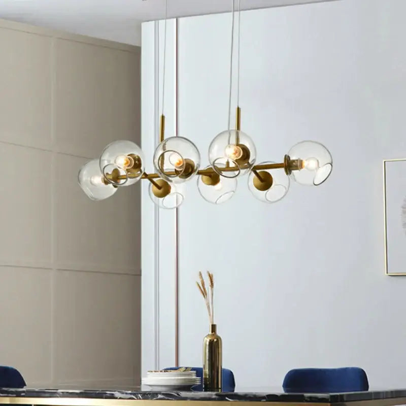Modern brass glass ball pendant light featuring gold-toned metal and clear glass globe shades for kitchen decorbites decor