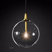 Modern brass glass ball pendant light with clear glass globe, brass fixture, and black cord for kitchen decorbites pendant light