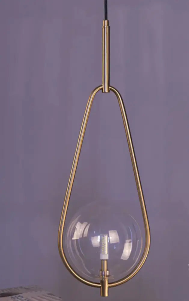 Modern brass glass ball pendant lighting with clear glass globe and sleek brass frame for bedroom decorbites glass ball