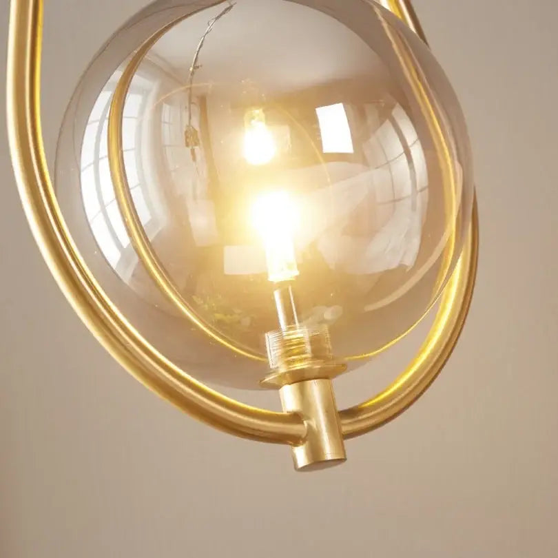 Modern brass glass ball pendant lighting with warm-toned brass frame and clear glass globe ideal for bedroom decorbites glass ball