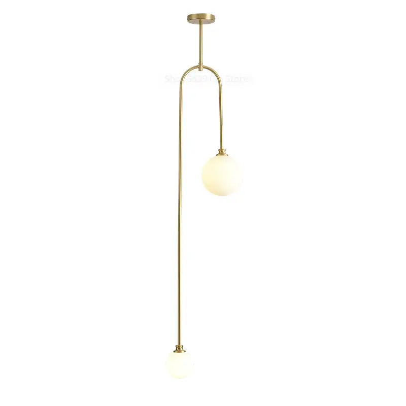 Modern brass glass ball pendant lights featuring two frosted globes on slender curved arms for dining room decorbites