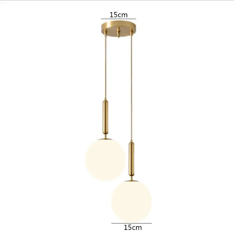 Modern brass glass ball pendant lights featuring gold-toned rods and frosted glass ball shades for kitchen decor