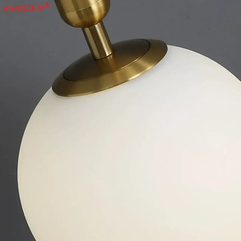A sleek frosted white glass ball pendant light with polished brass fixture ideal for modern kitchen decorbites brass glass decor