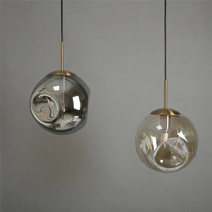 Two modern brass glass ball pendant lights with silver reflective and amber translucent globes for kitchen decorbites glass ball set
