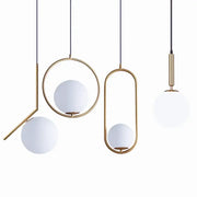 Modern brass glass ball pendant lights with frosted white spherical shades for kitchen decor by decorbites