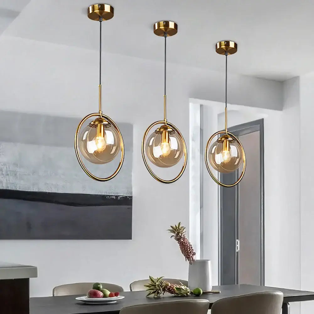 Three modern brass glass ball pendants with gold metal frames and smoked glass spheres for bedroom lighting decorbites glass ball
