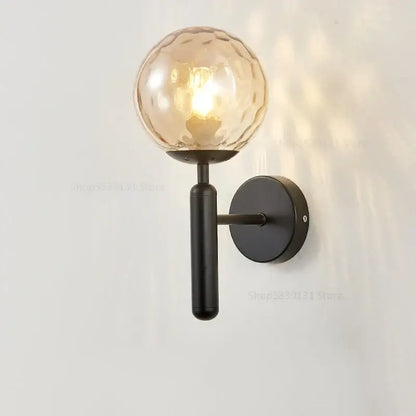 Modern black metal wall lamp with textured amber glass ball globe from decorbites glass ball wall collection for bedroom decor