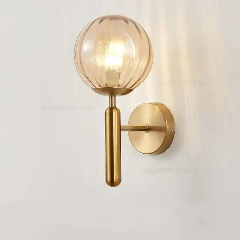 Gold-toned decorbites glass ball wall lamp with brushed brass finish and ribbed texture for modern bedroom decor
