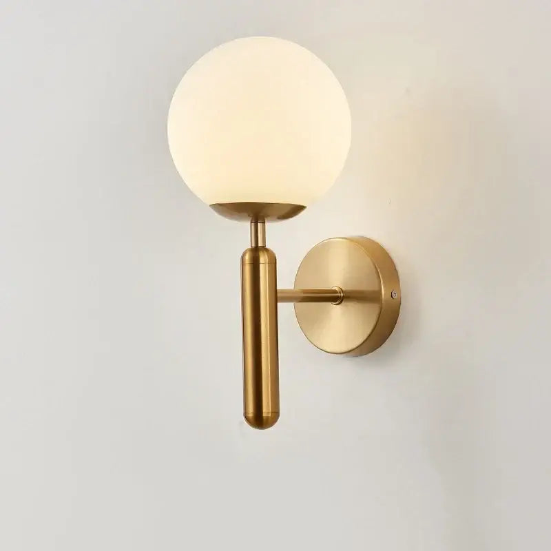 Modern brass glass ball wall lamp with gold-toned wall sconce and frosted glass globe for stylish bedroom decorbites glass ball