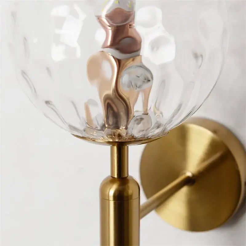 Modern brass glass ball wall lamp with gold-toned textured clear glass globe for stylish bedroom decorbites glass ball wall lamp