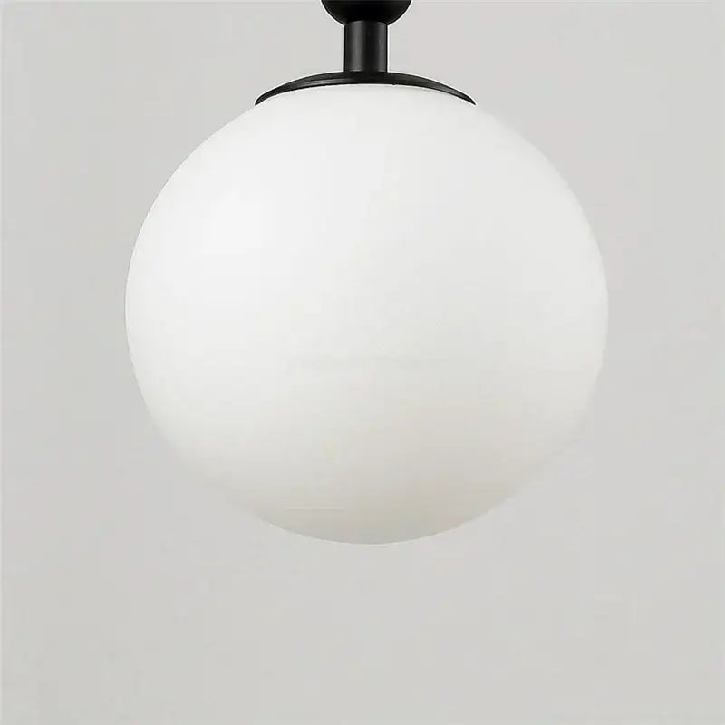 A sleek matte black spherical wall lamp with frosted white glass globe decorbites glass ball wall lamp for bedroom decor