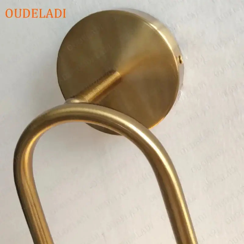 Brass-finished wall-mounted towel rack with sleek curved design complements decorbites brass glass ball wall sconce
