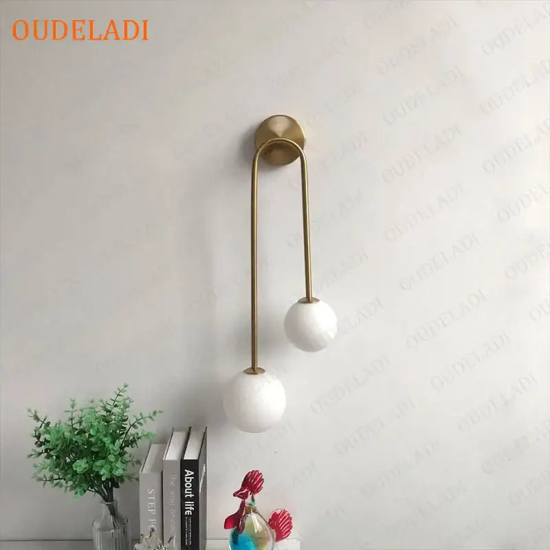 Modern brass glass ball wall sconce with gold-toned finish and two white spherical glass shades for bedroom decorbites brass glass
