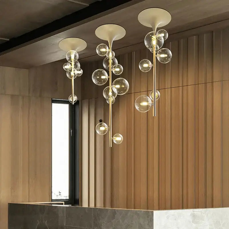 Modern brass glass bubble pendant light featuring cascading clear glass spheres and frosted white cones for dining decorbites pendant light