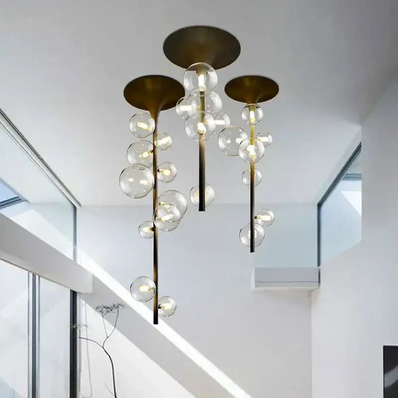 Modern brass glass bubble pendant light with cascading clear glass spheres and exposed bulbs for dining room decorbites pendant light