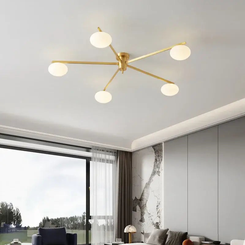 Modern brass glass ceiling lamp with five gold-toned frosted globes in a starburst design for living room decorbites brass glass