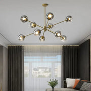 Modern brass glass chandelier with clear glass shades featuring spherical globes for elegant living spaces and dining rooms
