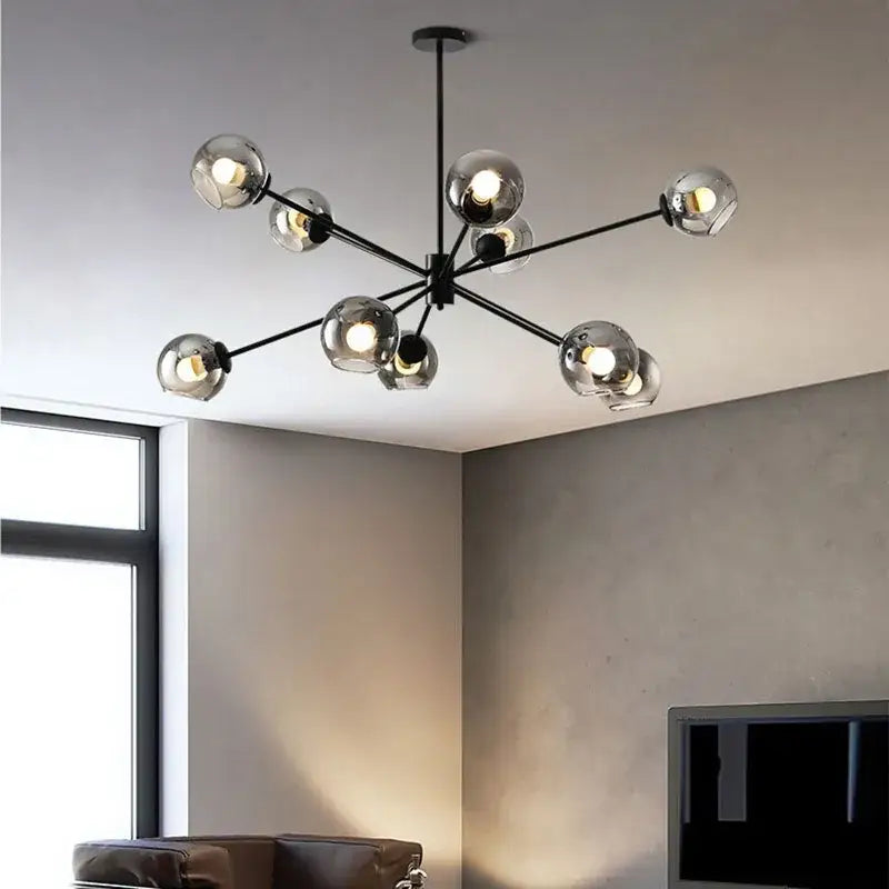 Modern black metal glass chandelier with multiple spherical clear glass shades emitting warm light for living spaces