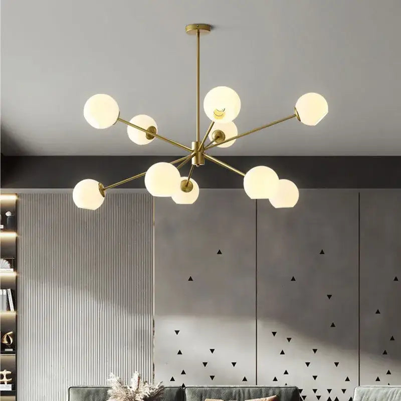 Modern brass glass chandelier with gold tone and frosted globe bulbs featuring clear glass shades for living spaces