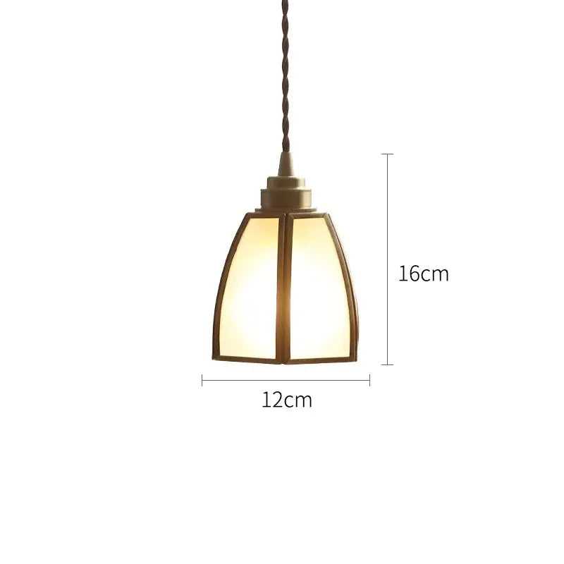 A warm-toned modern brass glass copper led pendant light with geometric shade and twisted cord for dining room