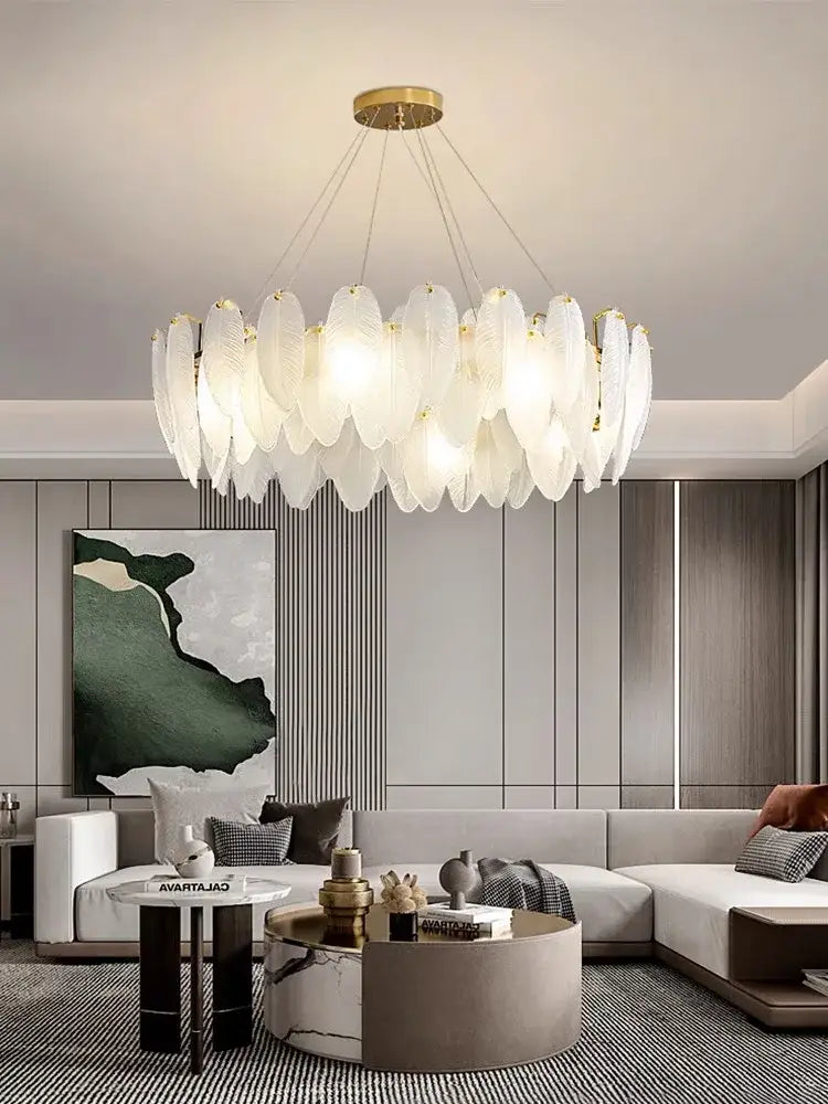 Modern brass glass feather chandelier with white feather shapes and gold accents for dining room ceiling lighting