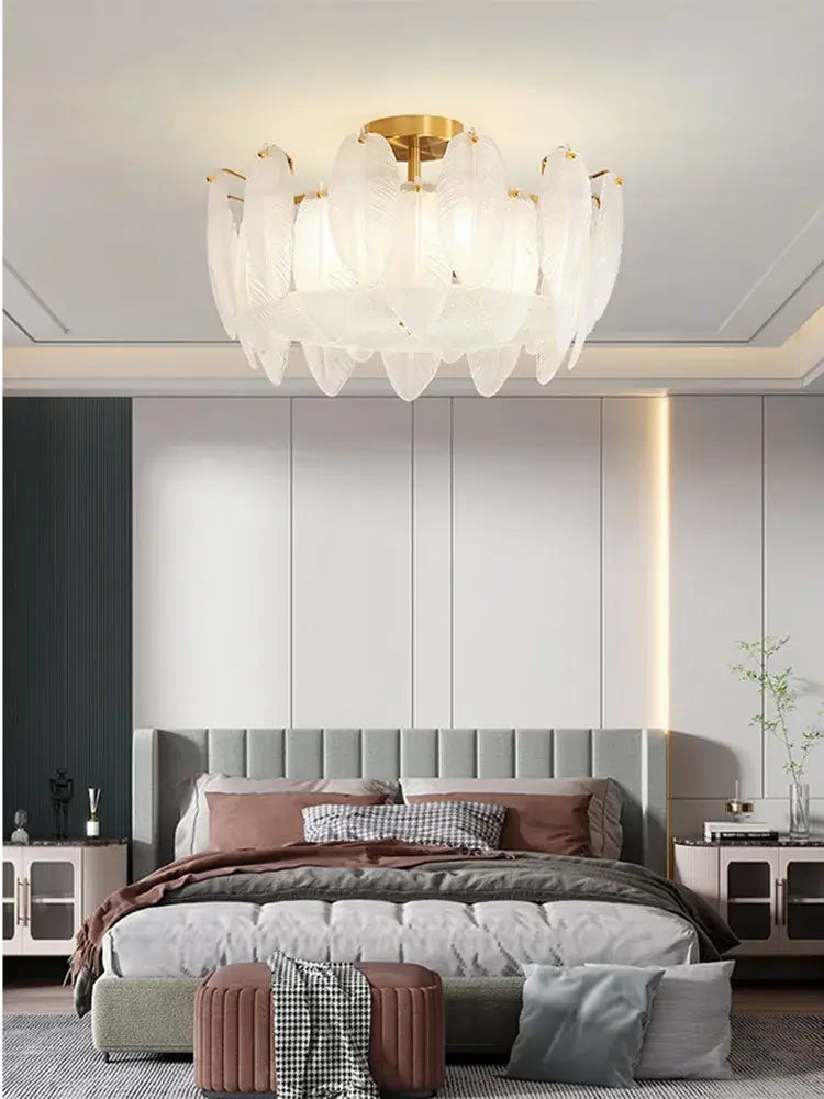 Modern brass glass feather chandelier with white feather-shaped glass and gold-toned central fixture for dining room