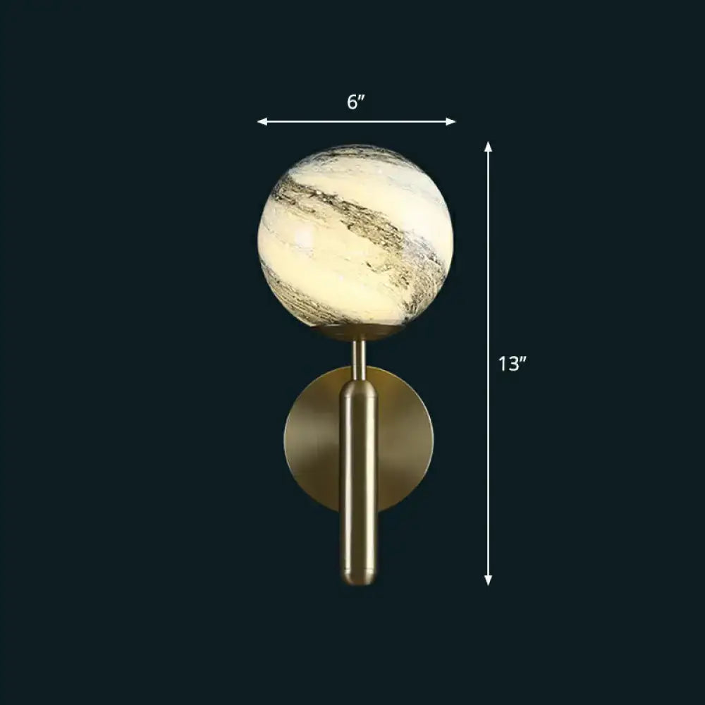Modern brass glass globe wall mount light with a marble-patterned glass globe and warm ambient lighting for living room