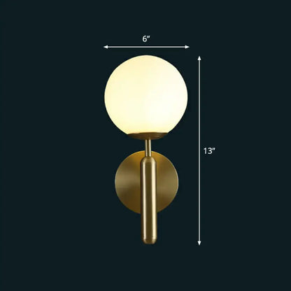 Modern brass glass globe wall mount light featuring a gold finish and frosted spherical glass for living room use