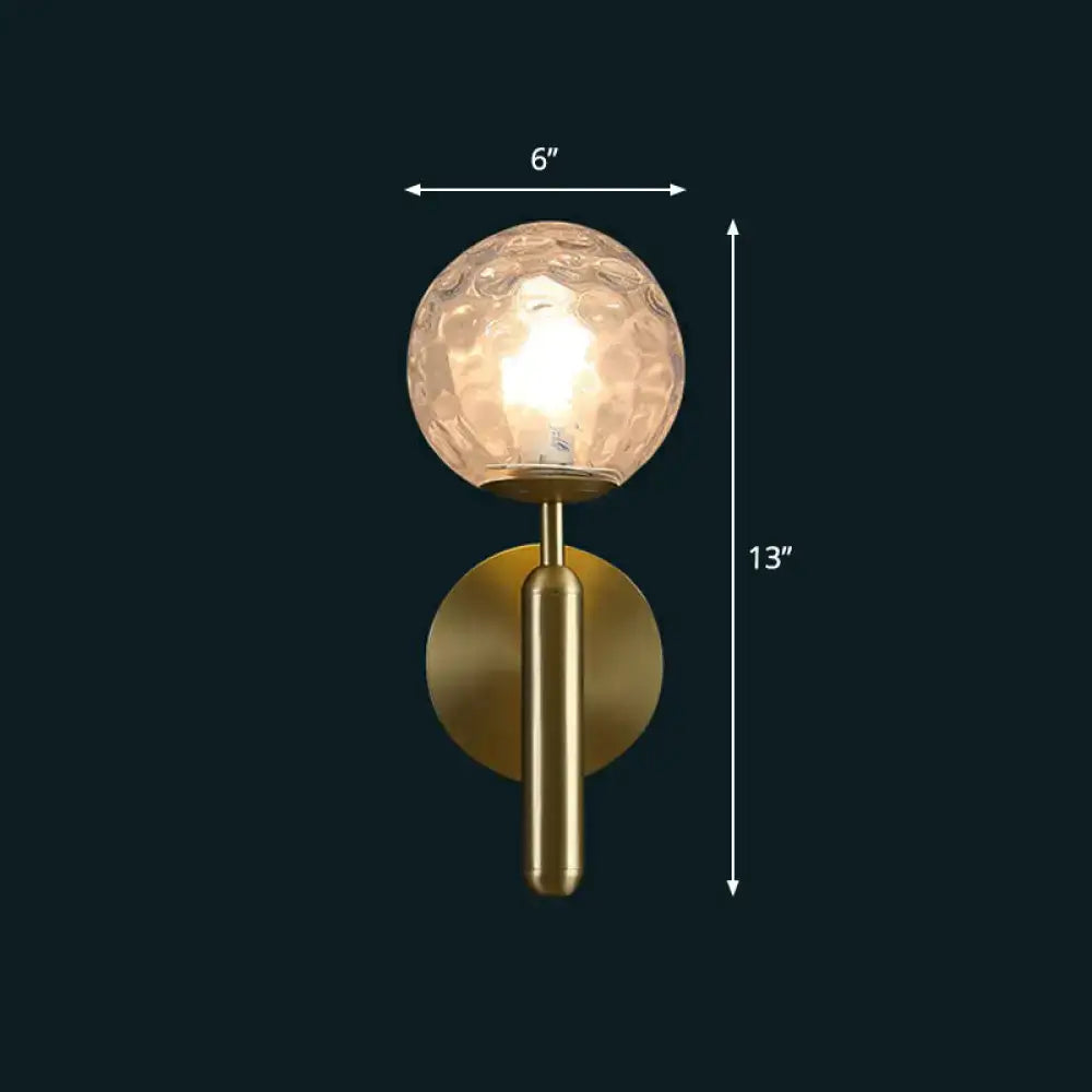 Modern brass glass globe wall mount light with gold-toned textured frosted globe and cylindrical stem for living room sconce