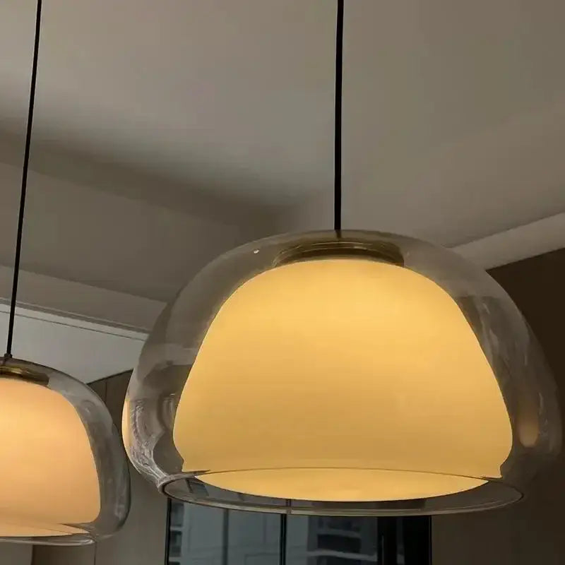Modern brass glass jelly pendant lamp with warm-toned translucent dome glass and black cords for dining room decorbites glass jelly