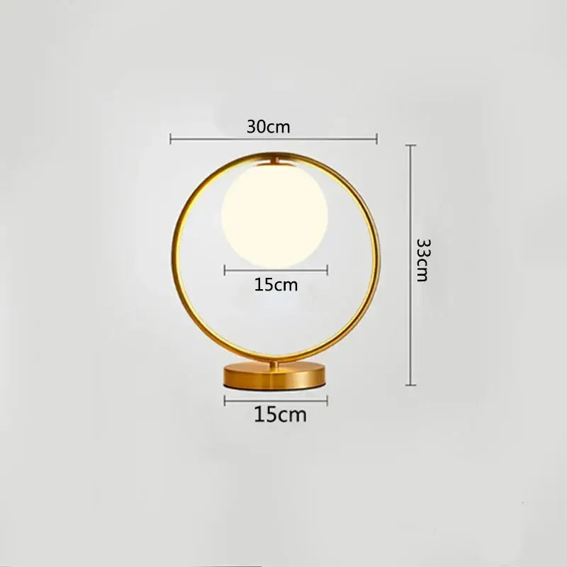 Modern brass glass led table lamp with gold-toned circular frame and glowing bulb ideal for bedroom reading desk decorbites brass glass