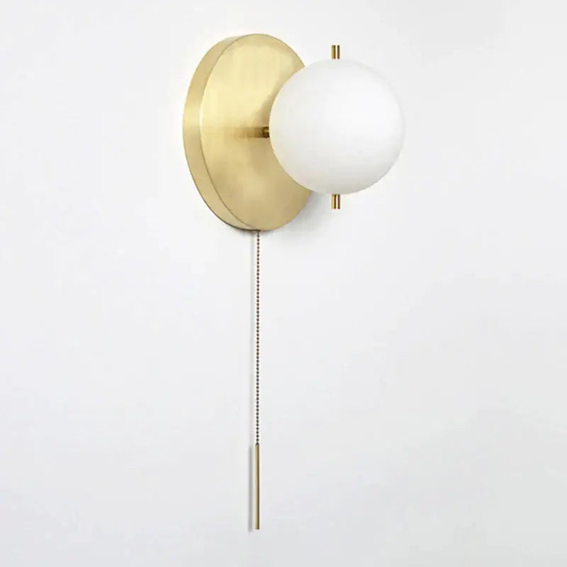 Modern brass glass round wall lamp with gold-toned wall sconce and frosted white spherical shade with pull chain