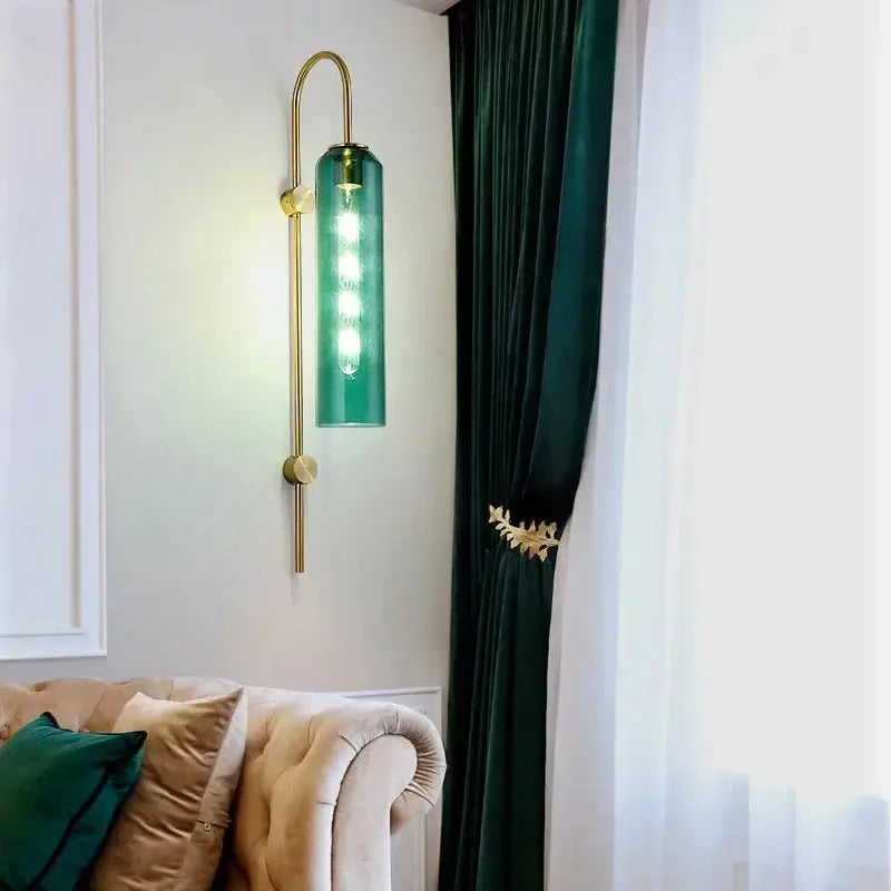 Modern brass glass sconce wall lamp with a sleek curved brass frame and green translucent glass shade for living room