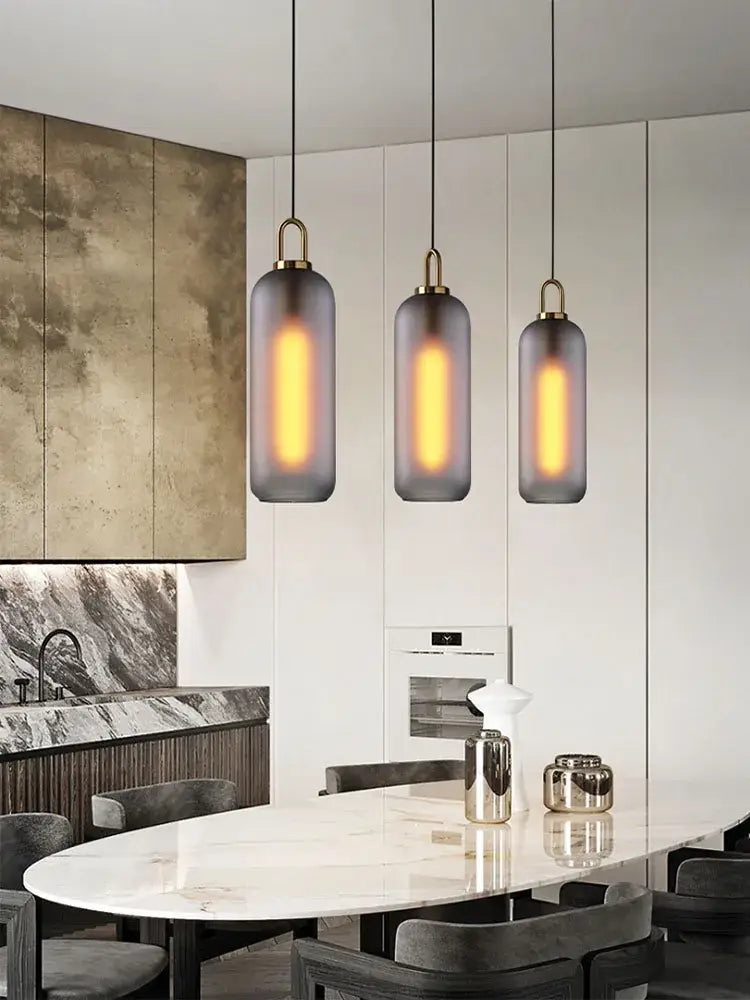 Modern brass glass staircase chandelier with smoked glass shades and brass accents over marble dining table