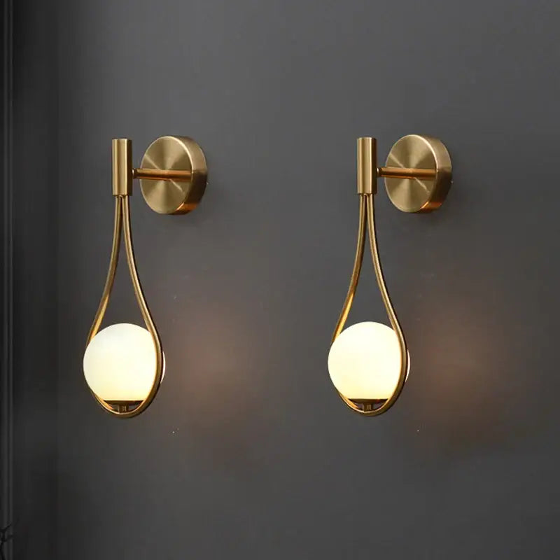 Pair of modern brass glass wall lamps with frosted globe shades in teardrop frames for bedroom lighting decorbites brass glass