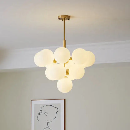 Modern brass globe pendant lamp with gold-toned finish and frosted glass globes for dining room lighting
