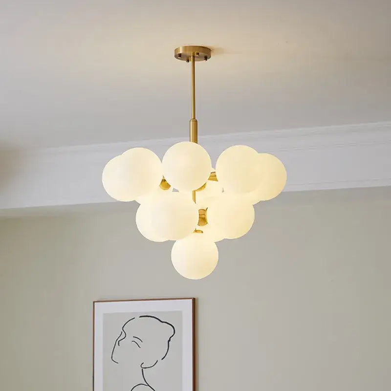 Modern brass globe pendant lamp with gold-toned finish and frosted glass globes for dining room lighting