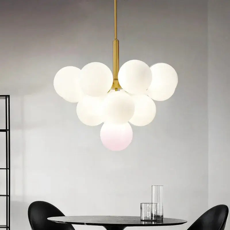 Modern brass globe pendant lamp featuring gold-toned metal and frosted white glass globes clustered together