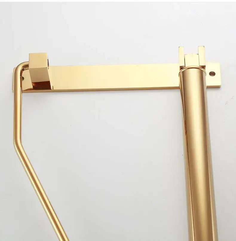 Modern brass gold wall clothing rack featuring a gold-colored metal toilet paper holder with sturdy mounting brackets decorbites brass gold